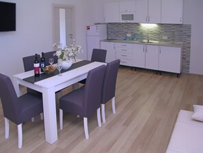 Apartment, Multiple Beds | Private kitchen | Fridge, stovetop, electric kettle, cookware/dishes/utensils