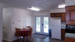 Une cuisine de taille réduite, équipée d’un réfrigérateur, d’une cuisinière et de meubles de rangement en bois.