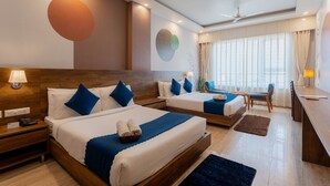 A hotel room with two beds, a desk, and a seating area. - Moustache Rishikesh Luxuria - Hostel (Srinagar)
