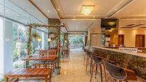 A modern hotel lobby with wooden furniture, a check-in desk, and a view of the outdoors. - Moustache Rishikesh Luxuria - Hostel (Srinagar)