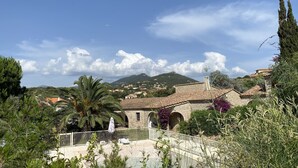 Eine Villa mit Pool, umgeben von üppiger Vegetation und einem Berg im Hintergrund.