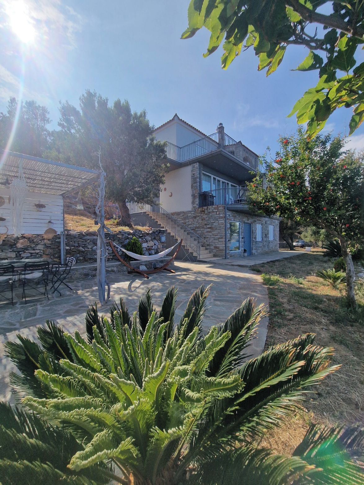 A house with a stone exterior, a balcony, and a hammock.