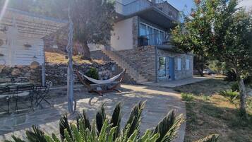 A house with a stone exterior, a balcony, and a hammock.