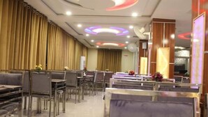 A modern dining area with tiered seating and ambient lighting. - Marjan Hotel (Rawalakot)