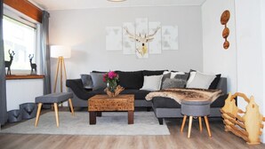 A modern living room with a sofa, coffee table, and decorative items.