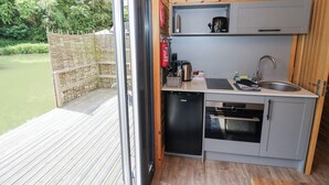 Een kleine keuken met een spoelbak, fornuis en vaatwasser.