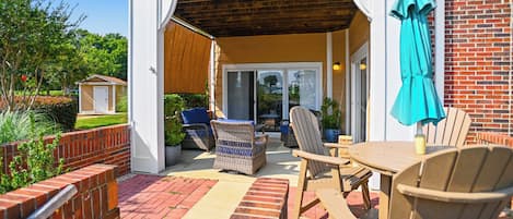 A patio area with outdoor furniture, a brick wall, and a view of the backyard.