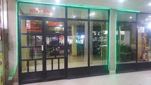 Area della reception di un hotel, con porte in vetro e un cartello che riporta la scritta 'Hotel Al Markaz Reception'.