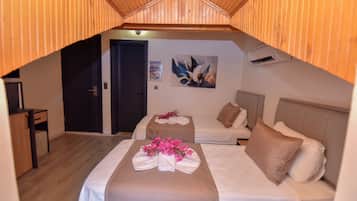 A cozy room with two beds, a desk, and a door.