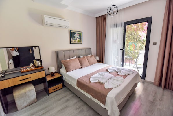 Una habitación de hotel moderna con una cama grande, un escritorio con espejo, una cafetera y un cuadro en la pared.