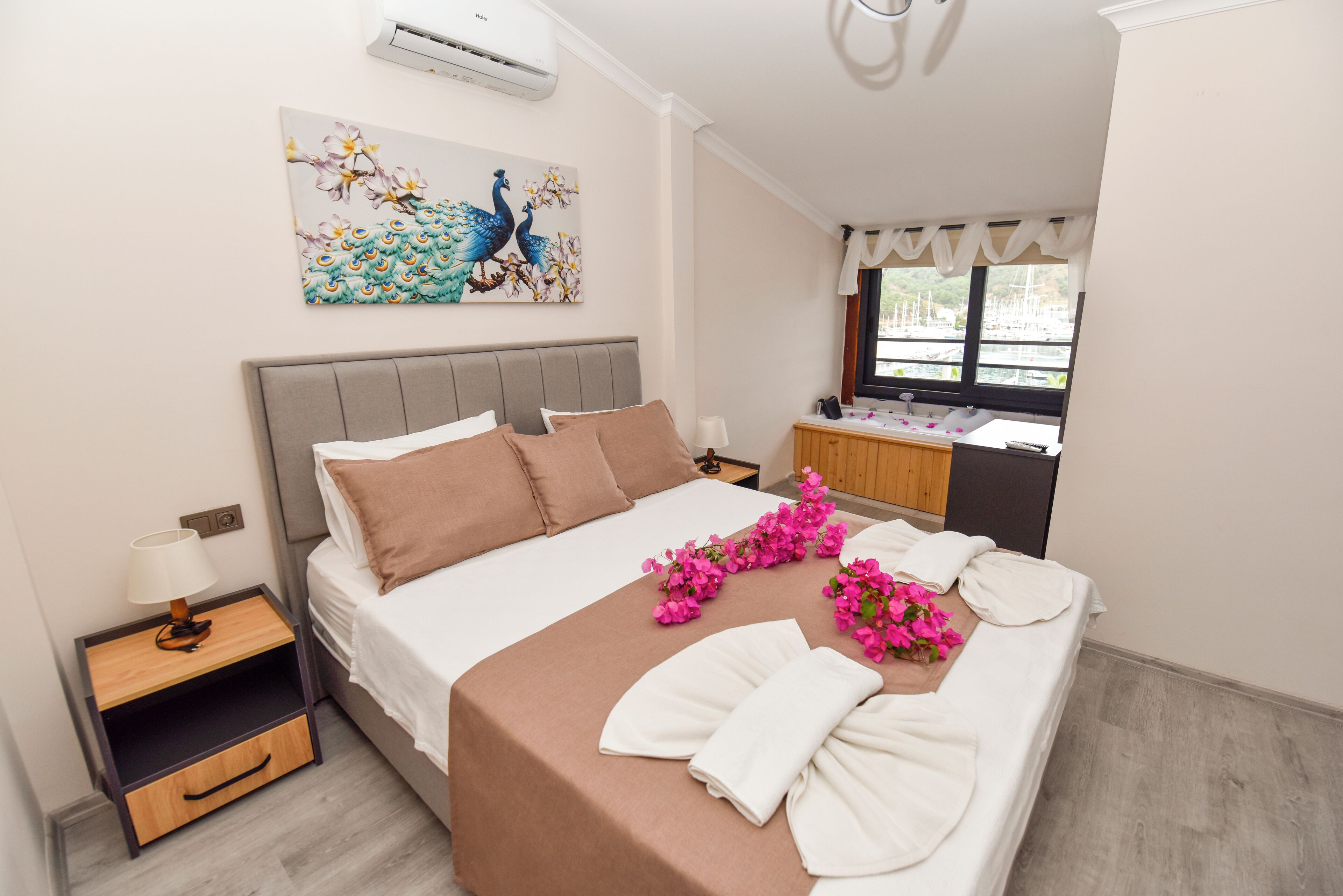 Ein ordentlich bezogenes Bett mit Kopfteil, ein Nachttisch mit Lampe und ein dekoratives Bild an der Wand.