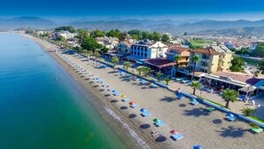 Ein Hotel an der Küste mit Blick auf den Strand, mehreren Zimmern und einem Restaurant.