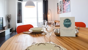 Una mesa de comedor dispuesta con platos, vasos y cubiertos, con una tarjeta de menú sobre la mesa.