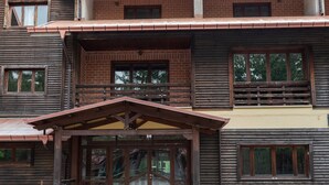 A multi-story wooden building with a balcony on the upper floor. - Olimpo Sila Hotel (Taverna)
