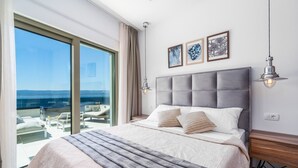 A bedroom with a large bed, a view of the sea, and a balcony with outdoor seating. - Seaview Villa Blue Lagoon with private heated pool, 2 jacuzzies, sauna, media room, 6 bedrooms, beach 70m (Pisak)