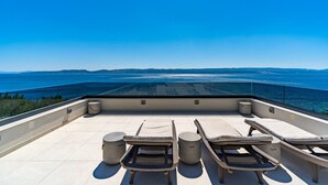 A rooftop terrace with lounge chairs and a view of the sea. - Seaview Villa Blue Lagoon with private heated pool, 2 jacuzzies, sauna, media room, 6 bedrooms, beach 70m (Pisak)