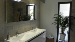 A modern bathroom with a large mirror, two sinks, and a potted plant. - Villa Exceptionnelle , Avec vue Panoramique (Venasque)