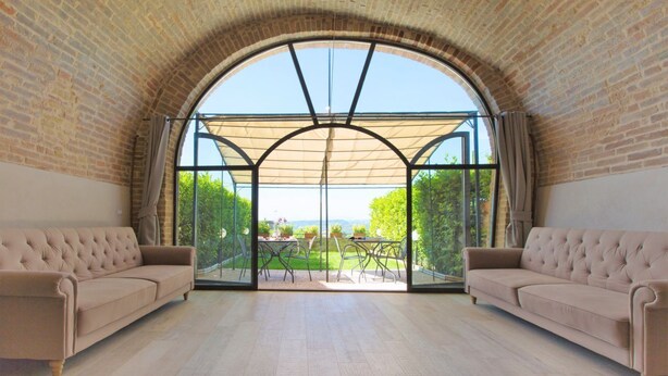 A spacious room with a high arched brick ceiling and large windows. - San Gimignano Town Garden - 4 pax (San Gimignano)