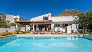 A modern villa with a swimming pool, outdoor seating, and a mountain backdrop. - Finca with pool Ca Na Tonina in Puerto Pollensa (Puerto Pollensa)