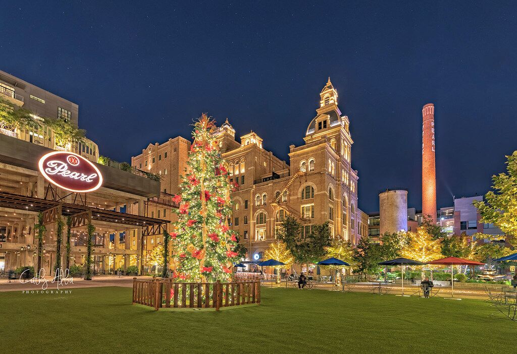 A historic building with a Christmas tree and a neon sign.