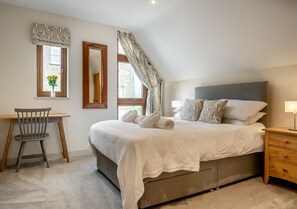 Restful retreat with a large bed, nightstand, and desk for a comfortable stay.
