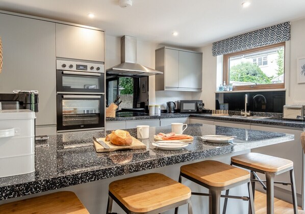 Enjoy cooking in this well-equipped kitchen with a central island, double oven, and range hood.
