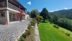 A stone building with a balcony, a cobblestone path, and a well-maintained lawn. - Casas da Tapada - Casa das Cortes (Guimarães)