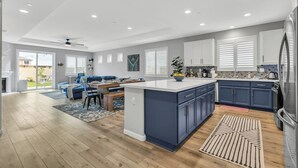 Een moderne keuken met een centraal eiland, inbouwmeubels en een groot raam.