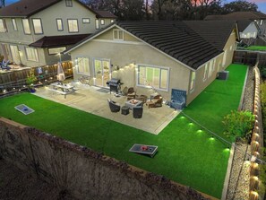 Uma casa com alpendre, área de estar externa e churrasqueira.