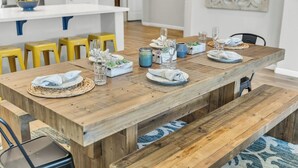 Een houten eettafel gedekt met borden, glazen en een middelpunt.