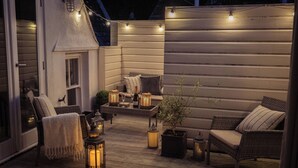 An outdoor patio with wicker furniture, lanterns, and string lights. - Fairhaven (Dartmouth)
