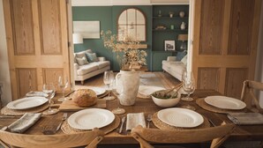 A dining table set with plates, glasses, and a vase of flowers. - Fairhaven (Dartmouth)