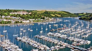 A marina filled with numerous boats, surrounded by a town with buildings and greenery. - Fairhaven (Dartmouth)
