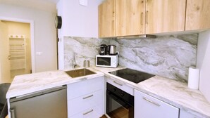 A compact kitchen with a microwave, coffee maker, and a dishwasher. - Viva Riviera Palais Holiday Design 2 Bedrooms (Cannes)