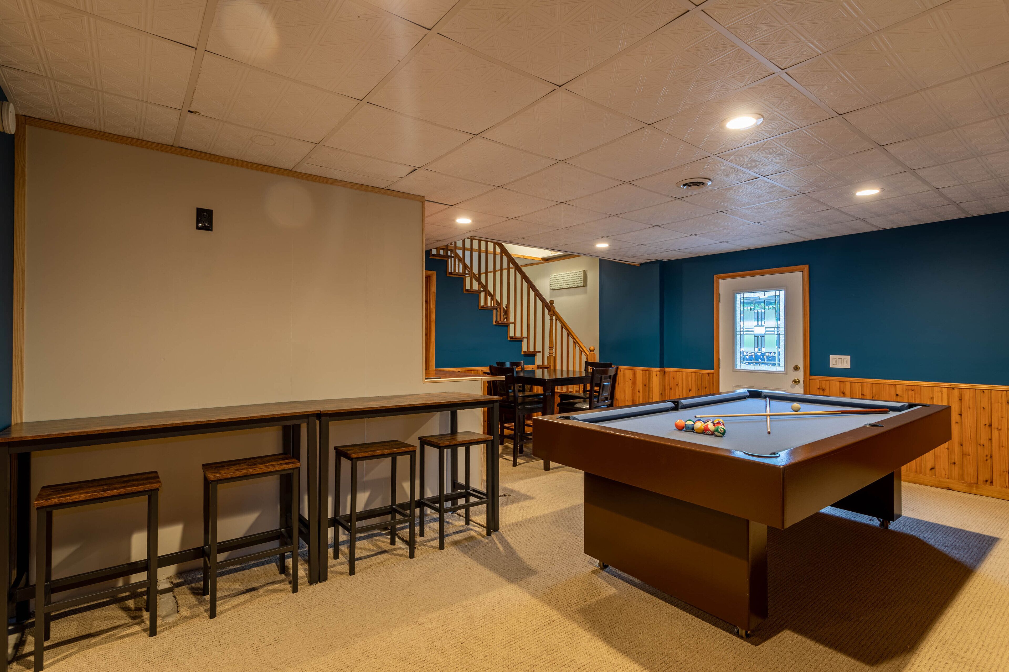 Rack 'em up in the lower-level game room at Sky High Chalet, with a full pool table and bar seating for the whole crew.