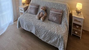 A cozy bedroom with a large bed, wooden headboard, and decorative wall art. - 45 m2 FULLY RENOVATED APARTMENT IN THE HEART OF THE ANGLES 4/6 BEDROOMS (Les Angles)