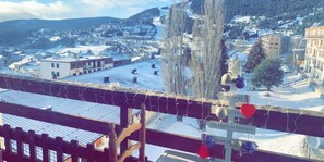 Une ville enneigée avec des bâtiments et un panneau indicateur.