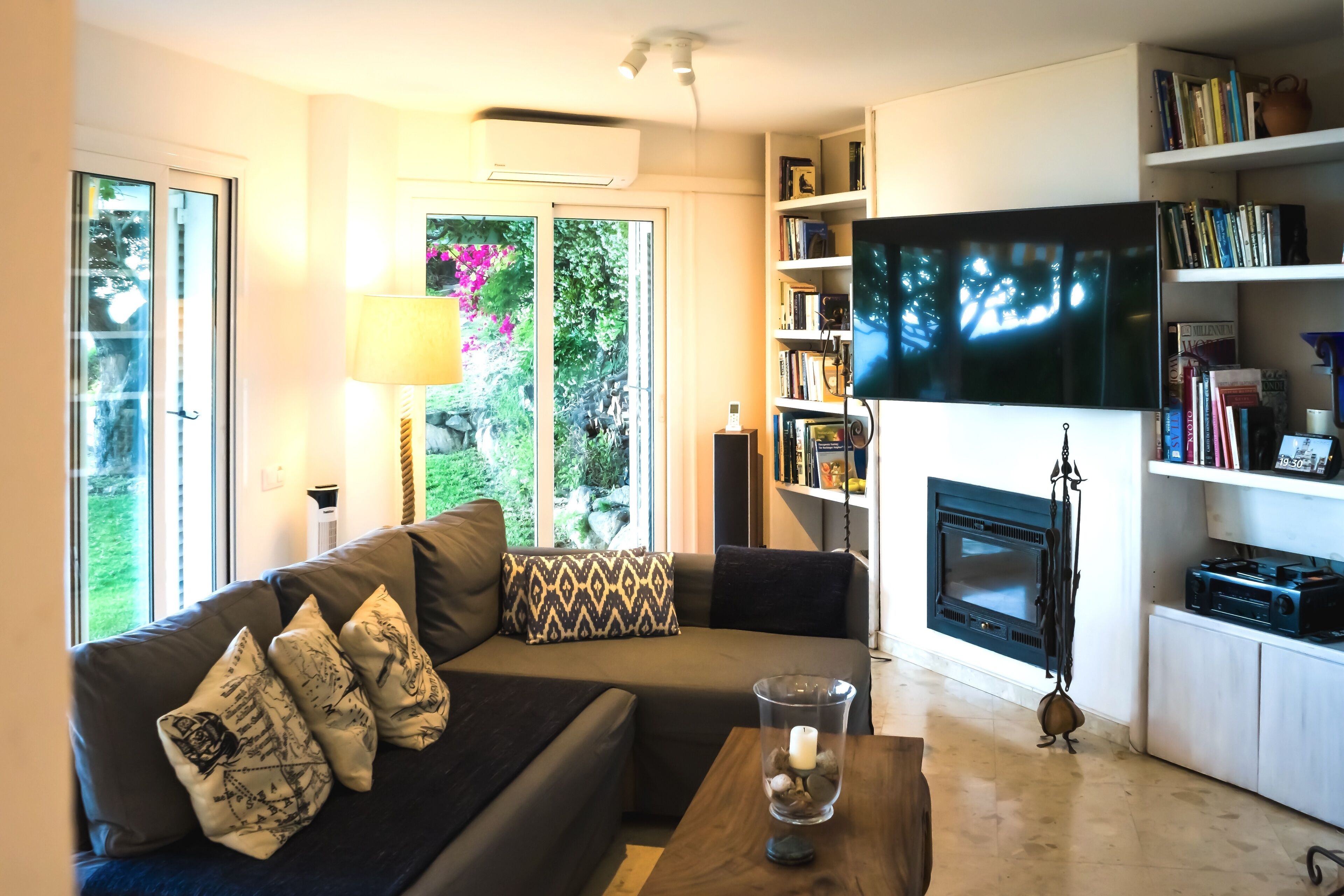 Een smart-tv, een open haard, boeken en een printer