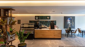 Una cafetería moderna con mostrador de madera, zona de estar y un menú.