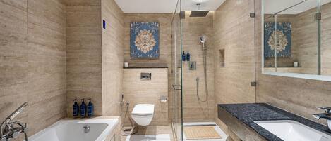 A modern bathroom with a bathtub, a shower, and a vanity with a large mirror.