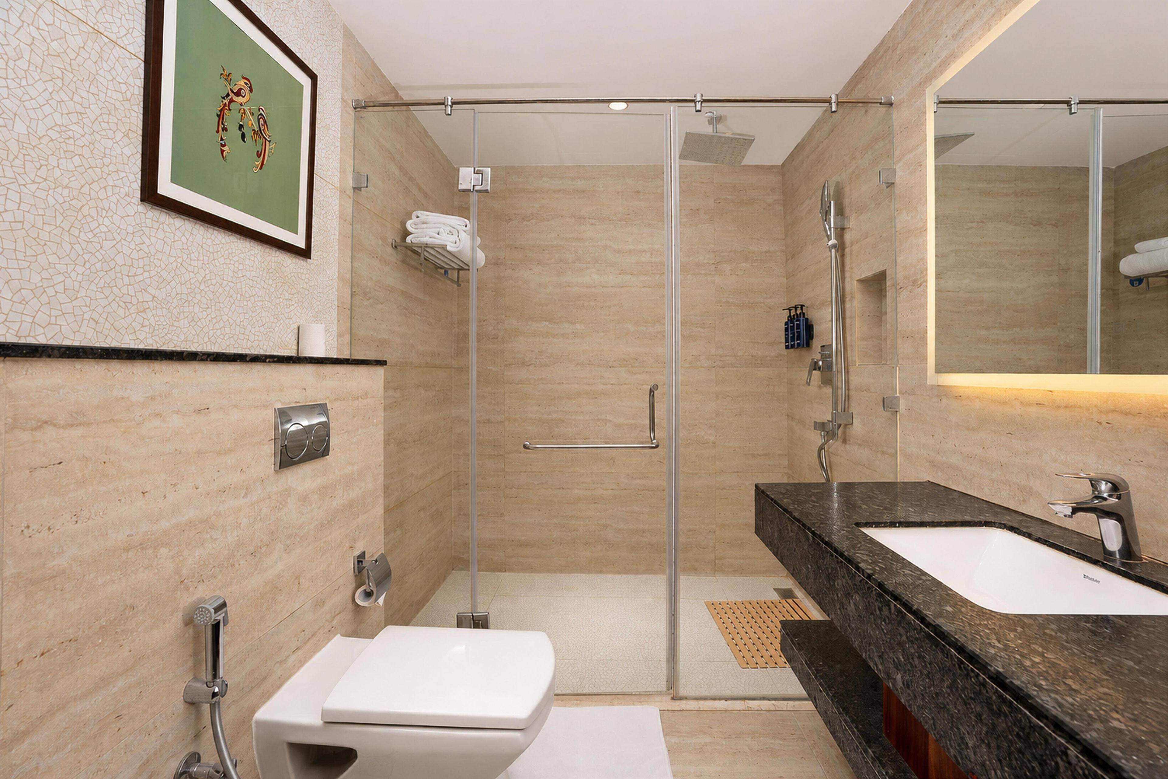 Un baño moderno con ducha de vidrio, lavamanos y retrete.