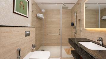 Un baño moderno con ducha de vidrio, lavamanos y retrete.