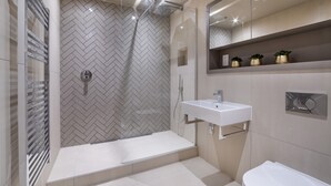 A modern bathroom with a herringbone tile shower, a white sink, and a toilet. - Apartment 28 Hudson Quarter Luxury Apartments - sleeps 4 guests  in 1 bedroom (York)