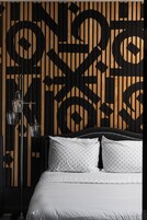 Una camera da letto con un letto, un muro decorato e una lampada da terra.