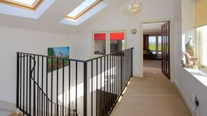 Un interior espacioso con tragaluces, una escalera y vistas al exterior.