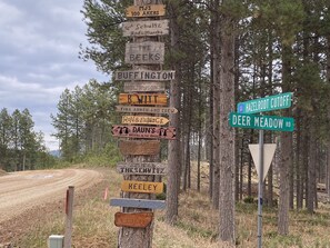 Un panneau indicateur en bois, doté de plusieurs flèches indiquant différentes directions et menant à diverses destinations.