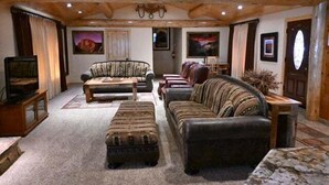A cozy living room with a fireplace, leather sofas, and a television. - (66) Grizzly Giant (3 Bedrooms Only) at The Redwoods In Yosemite (Yosemite National Park)