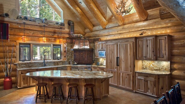 A spacious kitchen with a large island, wooden cabinets, and a stone backsplash. - (67) El Capitan (3 Bedrooms Only) at The Redwoods In Yosemite (Yosemite National Park)