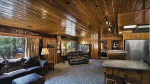 A wooden cabin interior with a living area, kitchen, and bar. - (72) Sequoia (1 Bedroom Only) (Yosemite National Park)