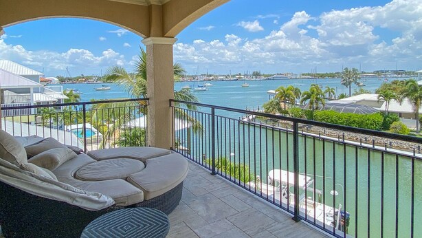 A balcony with a view of the marina and boats. - Luxury Construction, Heated Pool on Canal, 3 Minute Walk to sugar sand of FMB! (Fort Myers Beach)